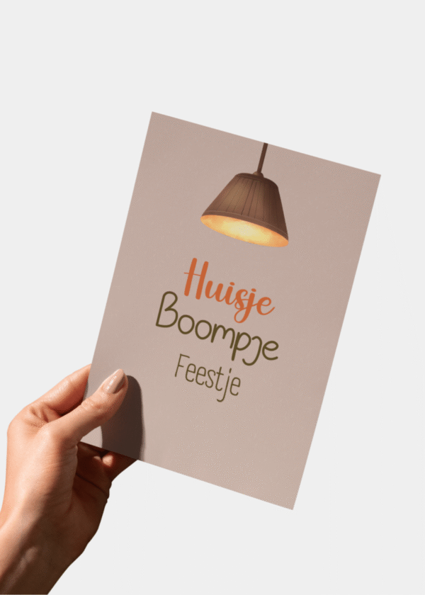 Close-up Housewarming kaart A6 in hand met 'Huisje Boompje Feestje' tekst. Toont de matte afwerking van de kaart.