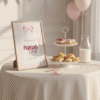Feesttafel decoratie met welkomstbord Aqiqah op een ezel, een etagère met scones en roze ballonnen.